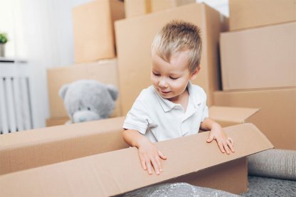 Kind spielt mit Umzugskartons